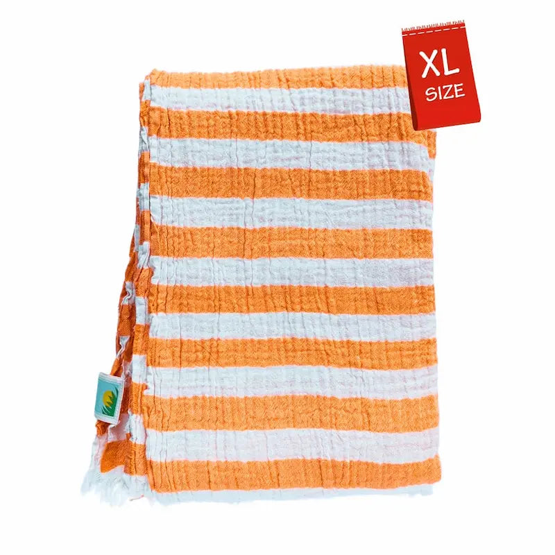 Close-up detail of breathable muslin texture of orange and white striped Summer Forever cotton beach towel with an XL size tag on a white background